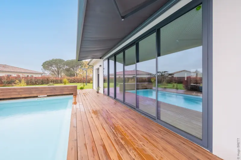 Coulissant aluminium FPEE Sensation 3 gris anthracite le long d'une terrasse en bois