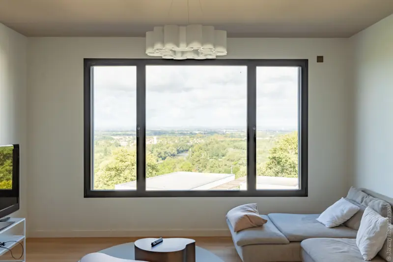 Fenêtre aluminium FPEE Sensation 2 noire à trois vantaux dans un salon