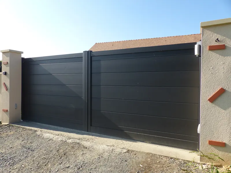 Portail coulissant aluminium FPEE Adelaïde gris anthracite entre deux piliers