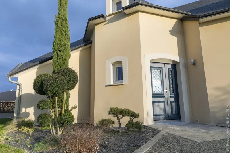 Porte d'entrée aluminium FPEE MONALU Diva bleu gentiane sur une maison traditionnelle