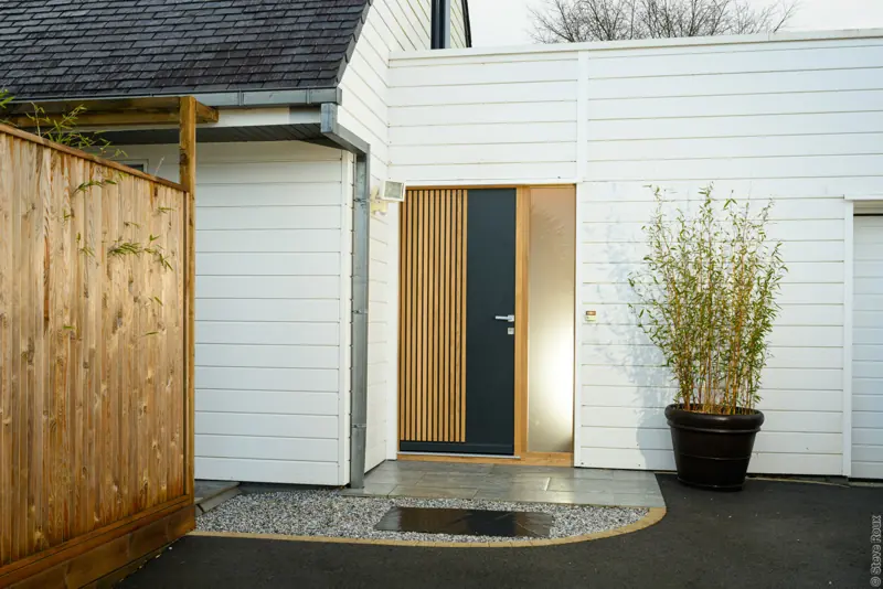 Entrée équipée d'une porte bois FPEE MONABOIS Clairevoie 12 avec fixe vitré