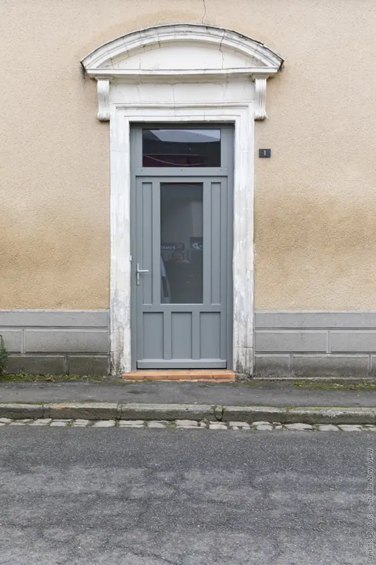 Porte d'entrée bois FPEE Tiers gris argent avec imposte sur une maison de ville