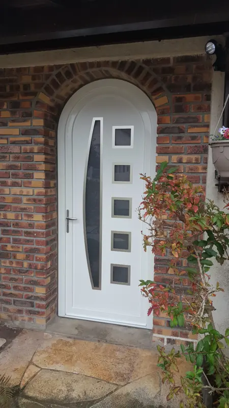 Porte d'entrée PVC FPEE Voile cintrée blanche dans un encadrement en brique