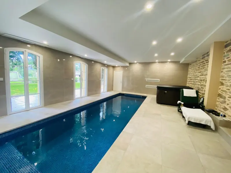 Portes-fenêtres PVC FPEE Sérénité 70 en arc surbaissé autour d'une piscine intérieure